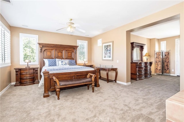 bedroom featuring light colored carpet, baseboards, and ceiling fan