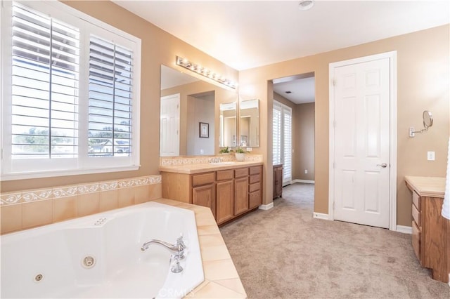 full bathroom featuring vanity, a tub with jets, and baseboards
