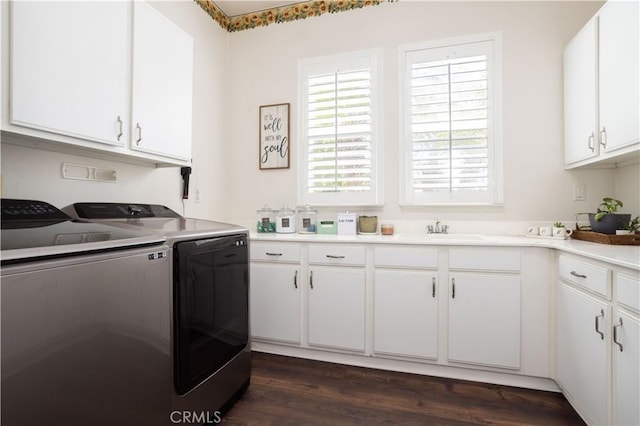 clothes washing area with washer and dryer, cabinet space, and dark wood-type flooring