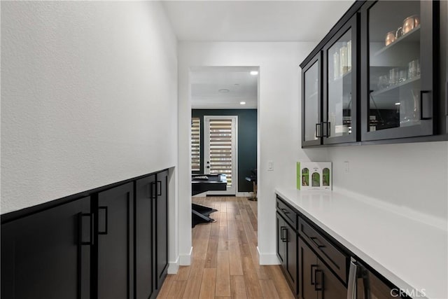 hallway featuring light wood-style flooring and recessed lighting