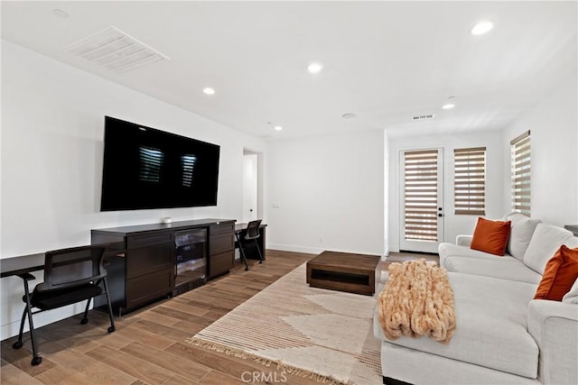 living room with light wood finished floors, recessed lighting, baseboards, and beverage cooler