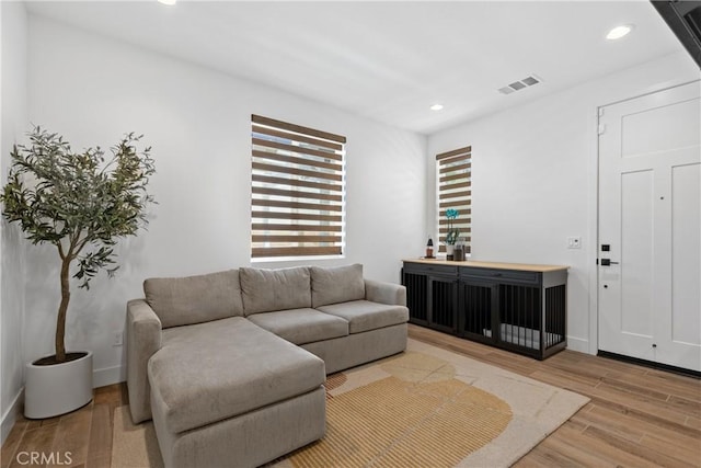 living area with recessed lighting, light wood finished floors, and baseboards