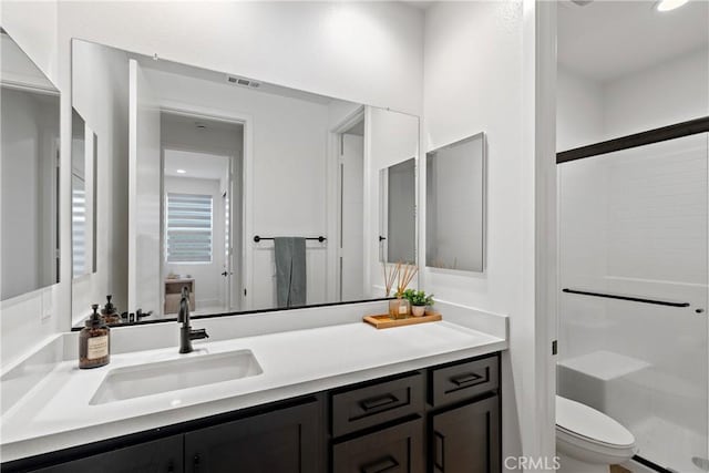 full bath with a stall shower, toilet, and vanity