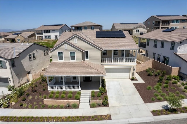 view of front of house with covered porch, a residential view, an attached garage, and driveway