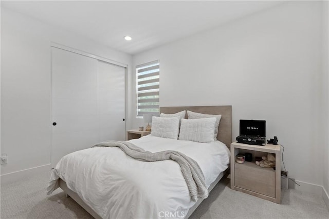 carpeted bedroom with a closet, baseboards, and recessed lighting