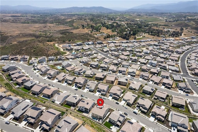 aerial view of property's location featuring a mountain backdrop and nearby suburban area
