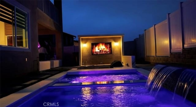 39494 Sagewood Rdg, Temecula, CA 92591 - pool at twilight with an in-ground hot tub, a lit fireplace, and an outdoor pool