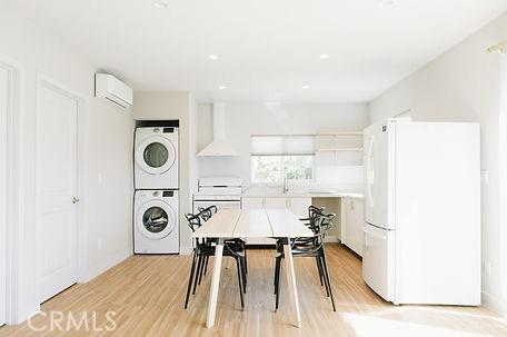 606608 Fairview Ave, Los Angeles, CA 90033 - dining space featuring stacked washing machine and dryer, a wall mounted air conditioner, and light wood-style flooring