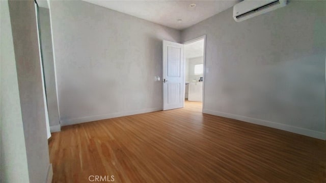 606608 Fairview Ave, Los Angeles, CA 90033 - empty room featuring a wall unit AC, wood finished floors, and baseboards