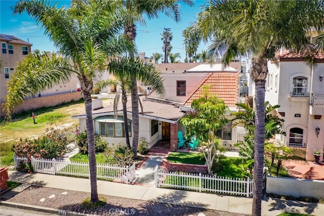 321 13th St, Huntington Beach, CA 92648 - mediterranean / spanish-style house featuring a tile roof, stucco siding, and a fenced front yard