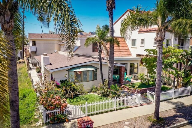 321 13th St, Huntington Beach, CA 92648 - view of front of house featuring stucco siding, a fenced front yard, and a tiled roof