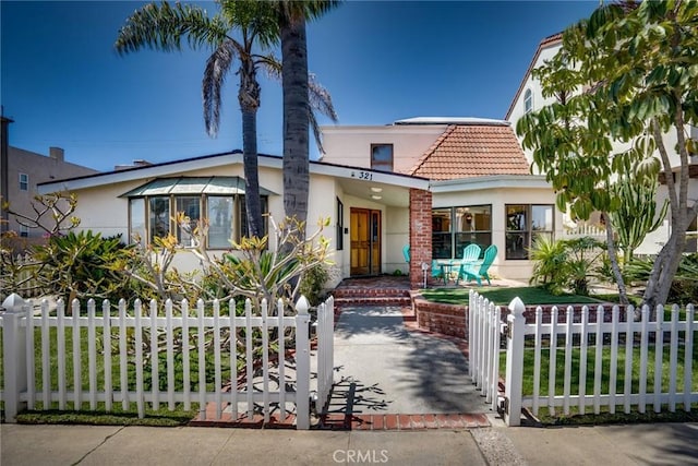 321 13th St, Huntington Beach, CA 92648 - view of front of home featuring a tile roof, stucco siding, a fenced front yard, and a gate