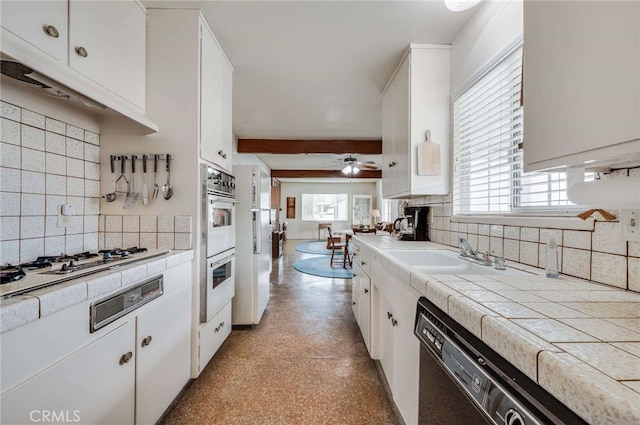 404 N San Jose Ave, Covina, CA 91723 - kitchen featuring tile counters, a sink, decorative backsplash, and white cabinetry