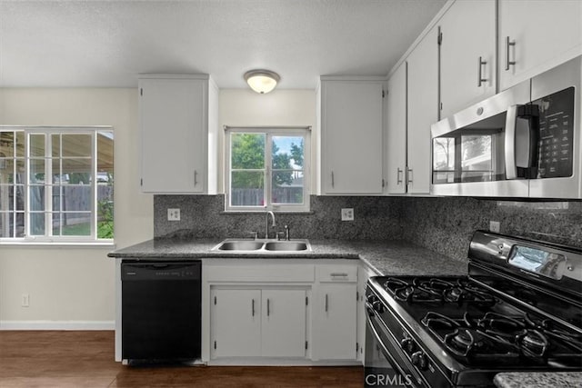 3439 De Anza Ave, Merced, CA 95348 - kitchen featuring black dishwasher, stainless steel microwave, range with gas stovetop, a sink, and decorative backsplash
