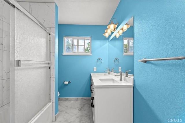 3439 De Anza Ave, Merced, CA 95348 - full bath featuring marble look tile flooring, double vanity, a chandelier, baseboards, and bath / shower combo with glass door