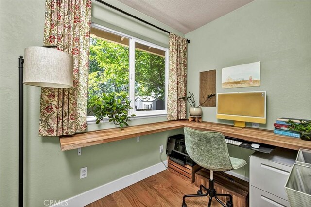 21425 Valley Oak Dr, Middletown, CA 95461 - office featuring built in study area, wood finished floors, baseboards, and a textured ceiling