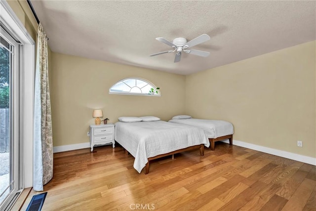 21425 Valley Oak Dr, Middletown, CA 95461 - bedroom featuring wood finished floors, baseboards, a textured ceiling, and a ceiling fan