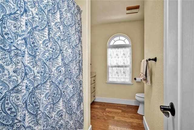 21425 Valley Oak Dr, Middletown, CA 95461 - bathroom featuring wood finished floors, toilet, vanity, baseboards, and a shower with shower curtain