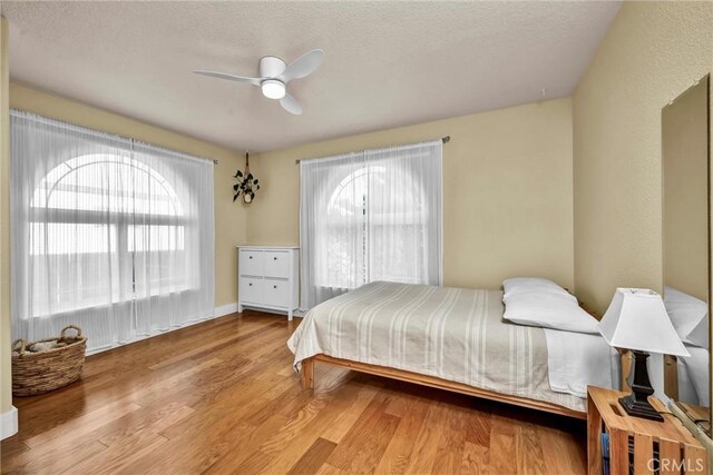 21425 Valley Oak Dr, Middletown, CA 95461 - bedroom featuring wood finished floors, a ceiling fan, a textured ceiling, and baseboards