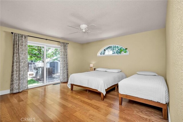 21425 Valley Oak Dr, Middletown, CA 95461 - bedroom with multiple windows, access to exterior, wood finished floors, and a textured ceiling