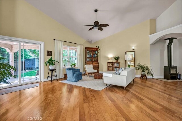 21425 Valley Oak Dr, Middletown, CA 95461 - living area featuring a ceiling fan, high vaulted ceiling, light wood finished floors, a wood stove, and baseboards