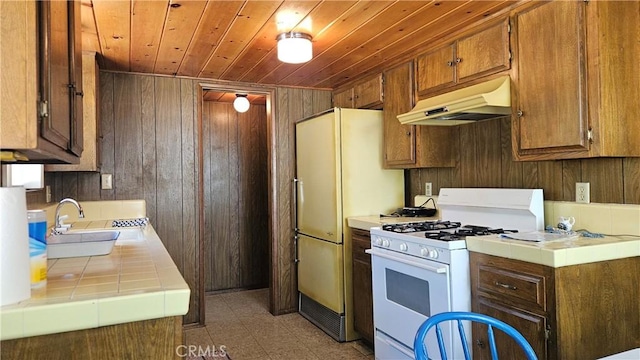 25 Manzanita, Running Springs, CA 92382 - kitchen featuring white appliances, under cabinet range hood, tile counters, wooden ceiling, and wooden walls