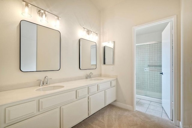 bathroom featuring a tile shower, double vanity, tile patterned flooring, and baseboards