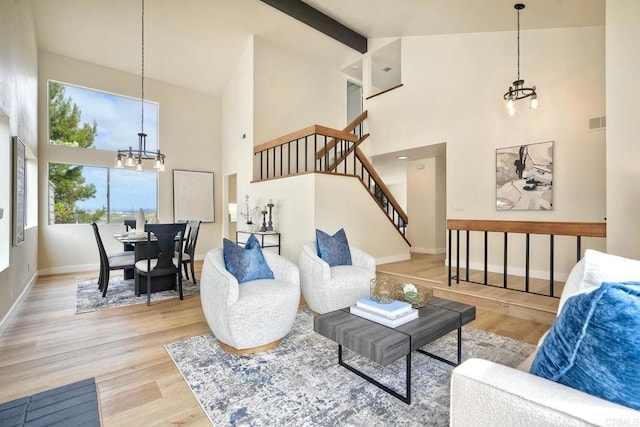 living room with high vaulted ceiling, a chandelier, wood finished floors, stairway, and baseboards