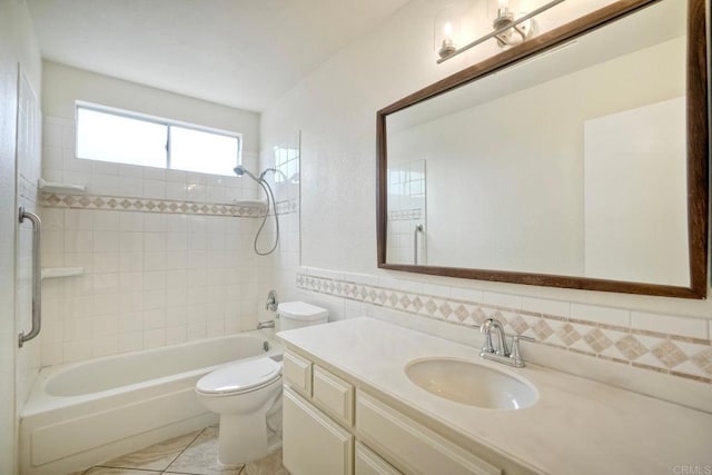 bathroom with vanity, toilet, washtub / shower combination, tile patterned floors, and tile walls