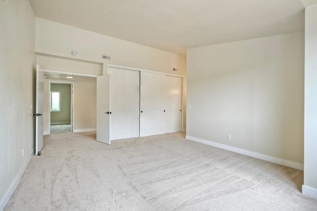 unfurnished bedroom with carpet, a closet, and baseboards