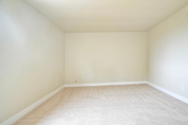 bonus room featuring light colored carpet and baseboards
