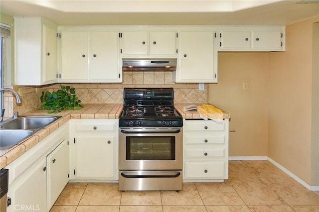 27314 Outrigger Ln, Helendale, CA 92342 - kitchen with stainless steel gas range, under cabinet range hood, a sink, backsplash, and light tile patterned floors