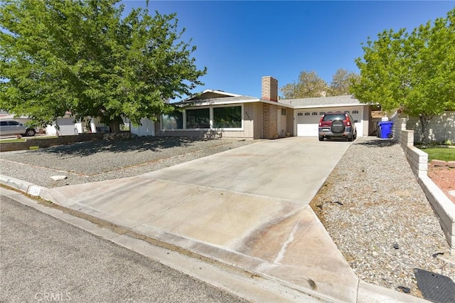 27314 Outrigger Ln, Helendale, CA 92342 - view of front of house featuring a garage, concrete driveway, and a chimney