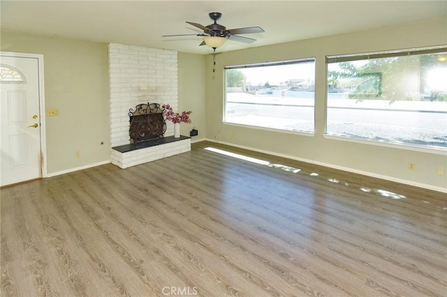 27314 Outrigger Ln, Helendale, CA 92342 - unfurnished living room with baseboards, wood finished floors, a ceiling fan, and a fireplace