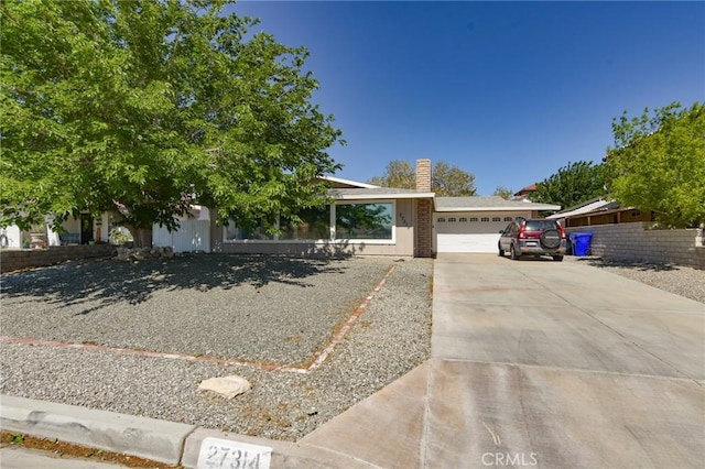 27314 Outrigger Ln, Helendale, CA 92342 - view of front facade with an attached garage, concrete driveway, and a chimney