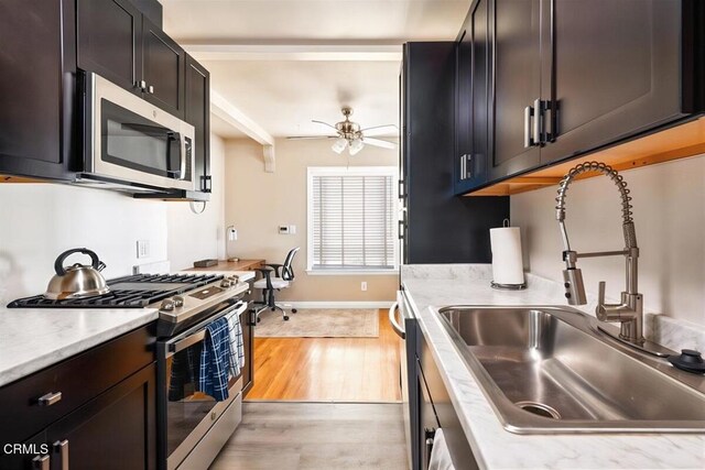 256 Melrose Dr, Oxnard, CA 93035 - kitchen featuring stainless steel appliances, a sink, ceiling fan, light wood-style flooring, and baseboards