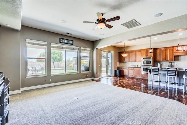13195 Trailwood Way, Apple Valley, CA 92308 - kitchen with brown cabinets, stainless steel double oven, a breakfast bar, open floor plan, and decorative light fixtures