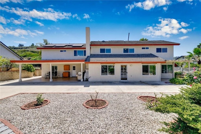 1158 Regal Canyon Dr, Walnut, CA 91789 - rear view of property featuring roof mounted solar panels, fence, a carport, a patio area, and stucco siding