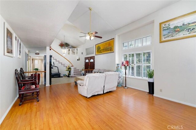 1158 Regal Canyon Dr, Walnut, CA 91789 - living room featuring stairway, ceiling fan, wood finished floors, baseboards, and high vaulted ceiling