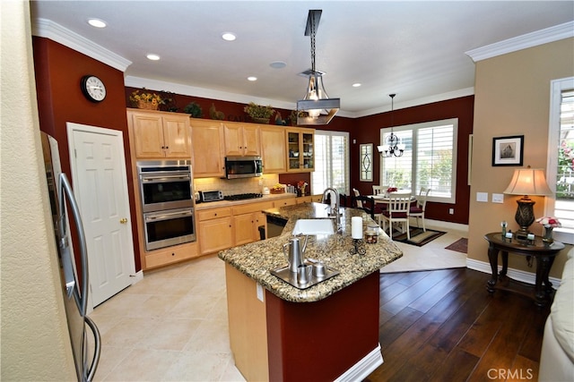 29424 Springside Dr, Menifee, CA 92584 - kitchen with a sink, black appliances, crown molding, baseboards, and a kitchen island with sink