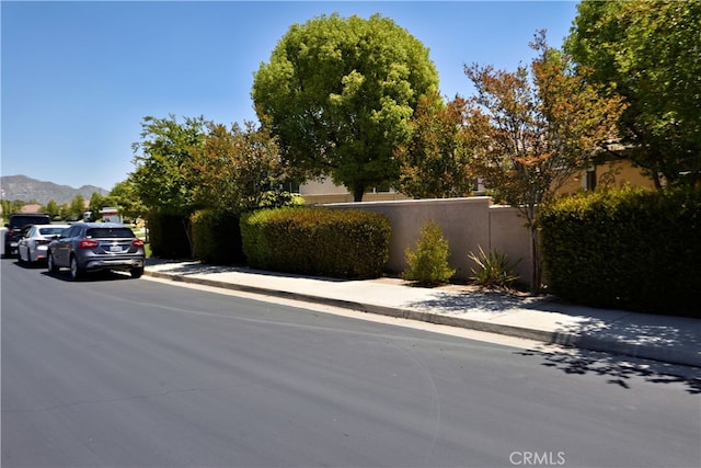 29424 Springside Dr, Menifee, CA 92584 - view of asphalt road featuring sidewalks, a mountain view, and curbs