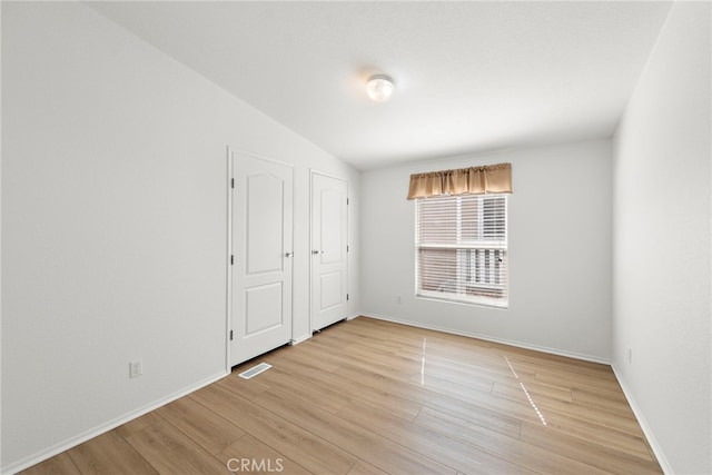 unfurnished bedroom with light wood-type flooring and baseboards