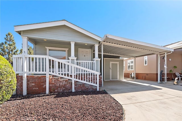 view of front of house with covered porch, driveway, and an attached carport