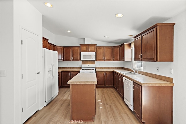kitchen with white appliances, a sink, a center island, lofted ceiling, and recessed lighting