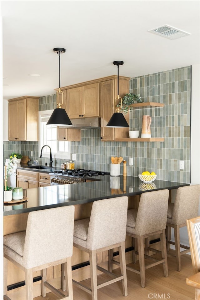 20010 Ingrum Way, Torrance, CA 90503 - kitchen with dark countertops, backsplash, light wood finished floors, and decorative light fixtures