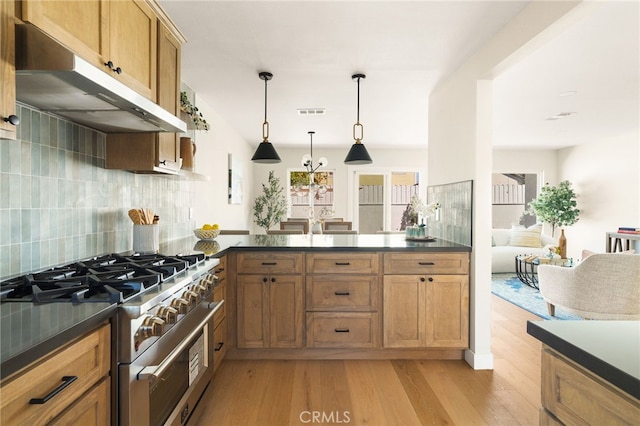 20010 Ingrum Way, Torrance, CA 90503 - kitchen with stainless steel range, under cabinet range hood, dark countertops, light wood finished floors, and decorative backsplash