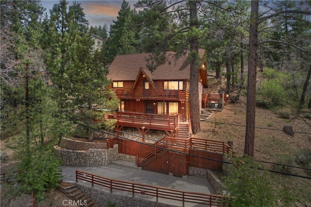 43214 Sunset Dr, Big Bear Lake, CA 92315 - back of house featuring stairs, a deck, a shingled roof, and a patio