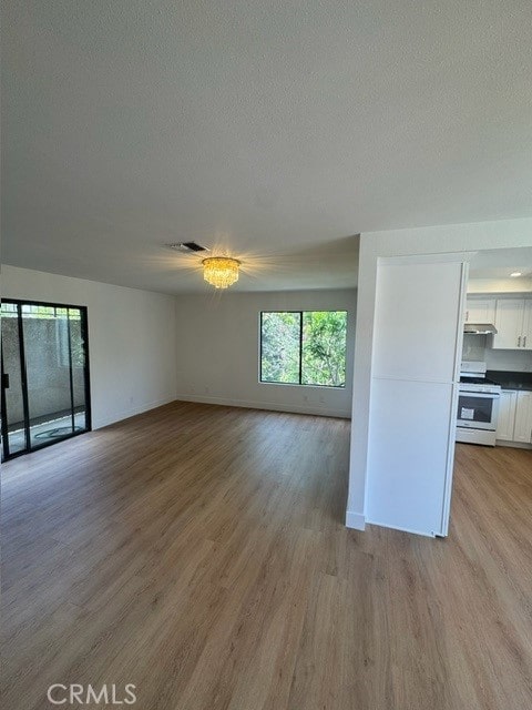 171 Junipero Serra Dr Unit D, San Gabriel, CA 91776 - unfurnished living room featuring light wood finished floors, baseboards, and a textured ceiling