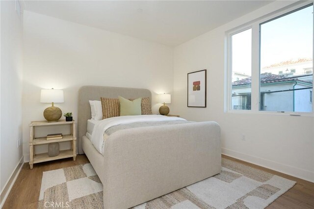 414 Main Unit 200, Huntington Beach, CA 92648 - bedroom with wood finished floors, baseboards, and multiple windows