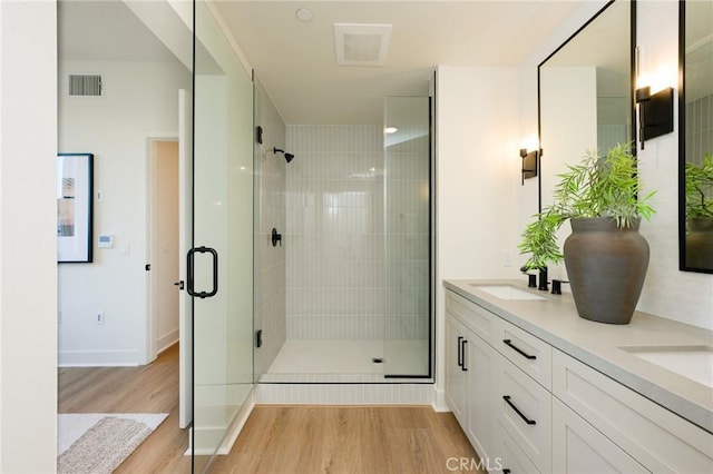 414 Main Unit 200, Huntington Beach, CA 92648 - bathroom featuring wood finished floors, a shower stall, double vanity, and baseboards